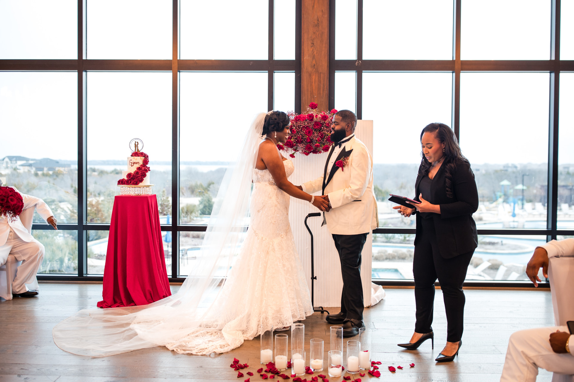 Jennifer Allen officiating a ceremony in front of tall windows