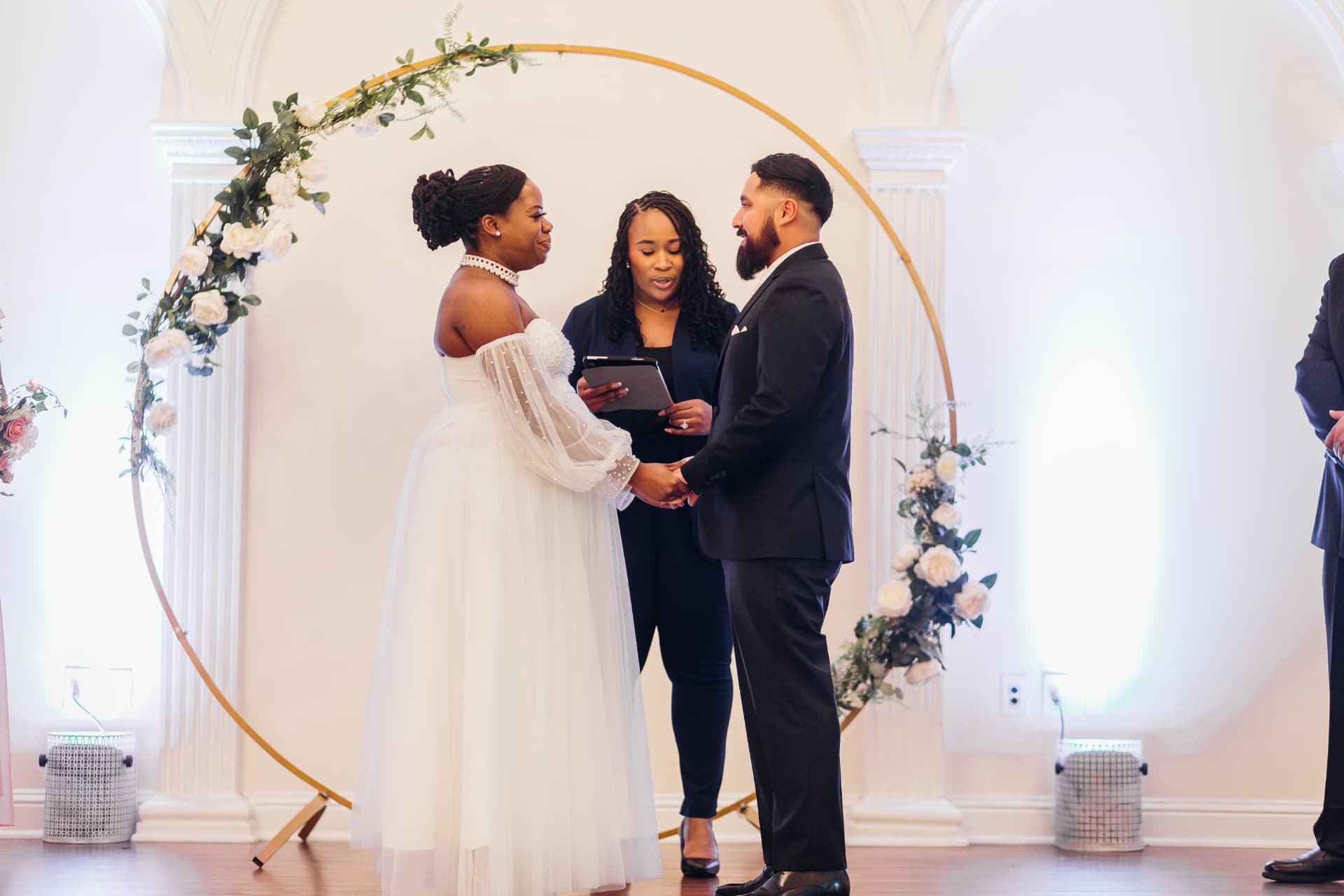 Jennifer Allen officiating under a floral arch
